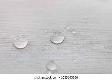 Water drops on white wooden surface made from larch wood covering by oil with wax.