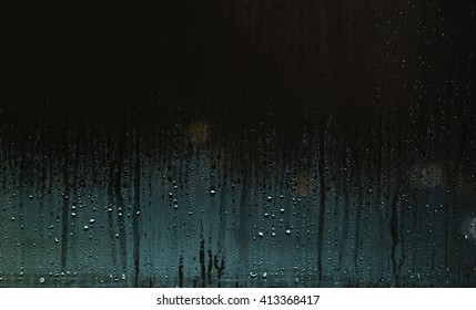 Water Drops On Window With Blue-green Glow