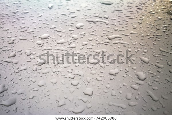 Water drops or rain on\
the roof of car.