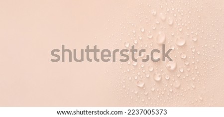 water drops of transparent gel serum on beige background 