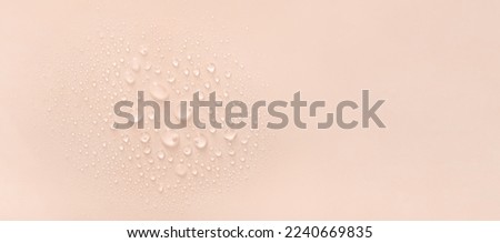 water drops of transparent gel serum on beige background 