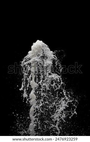 Water exploding into the air with a black background, vertical