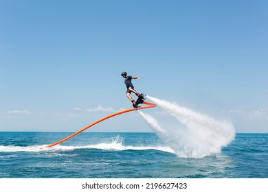 Water extreme sport. The guy is flying at the aquatic flyboard. A lot of water pressure - Powered by Shutterstock