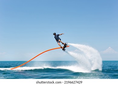 Water extreme sport. The guy is flying at the aquatic flyboard. A lot of water pressure - Shutterstock ID 2196627429