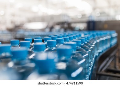 Water factory - Water bottling line for processing and bottling pure spring water into small bottles. Selective focus. - Powered by Shutterstock