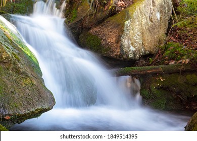 Water Falling In Cascade Over Mossy Rock Stone. Stream Flowing In Green Misty Forest. Clean Nature Freshness Natural Ecology Concept