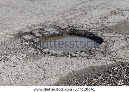 water filled pot hole in the road