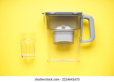 Water Filter Jug With Lemon On A Yellow Background. Top View.