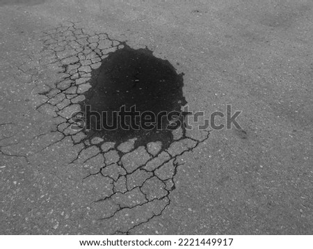 water flood on the pit in the old asphalt road with crack texture