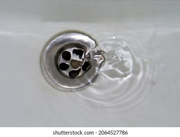 Water Flowing Away Into A White Stone Sink