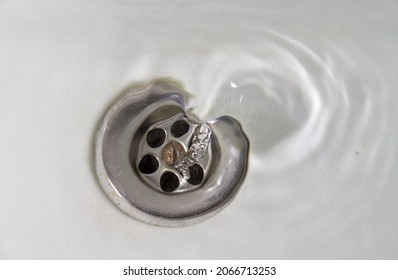 Water Flowing Away Into A White Stone Sink