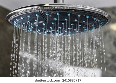 Water flowing from circle shower head in modern bathroom. - Powered by Shutterstock