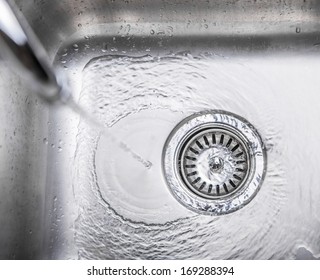 Water flowing down the hole in a kitchen sink - Shutterstock ID 169288394