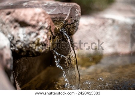 Water flowing down from a stone and irrigation channel in Cuzco Inca city in Peru