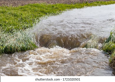 Water Flowing In Farm Field Waterway After Heavy Rain And Storms Caused Flooding. Concept Of Soil Erosion, Water Runoff Control And Management