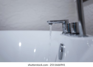 Water flowing from the faucet into luxury bathtub, preparing for spa recreation. Home interior decoration with lifestyle. Close-up and selective focus. - Powered by Shutterstock