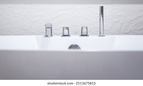 Water flowing from the faucet into luxury bathtub, preparing for spa recreation. Home interior decoration with lifestyle. Close-up and selective focus. - Powered by Shutterstock