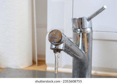 Water flowing from the faucet in the kitchen - Shutterstock ID 2353608755