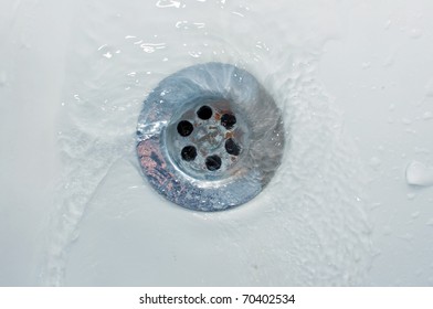 Water Flowing In A Spiral Down A Stainless Steel Drain, Top View