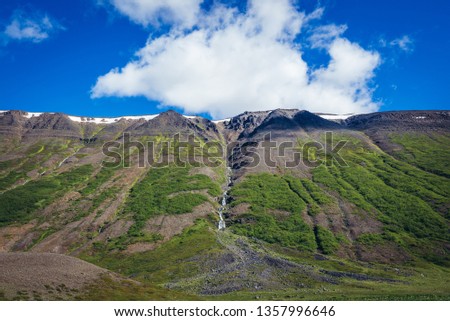 Water flows from a mountain next to Ljosavatn lake in Iceland
