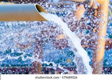 water flows from a pipe or water gushing out of the pipe close up
