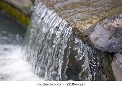 Water flows from the rocks in the residential garden  - Powered by Shutterstock