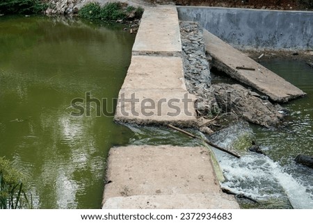 water flows in a small exit dam. Scenic view of river flowing in forest