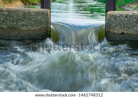 Water flows through the floodgate in the irrigation canal quickly.Water management, irrigation system, irrigation dam, irrigation canal To send to agricultural plots. To solve drought in northeast 