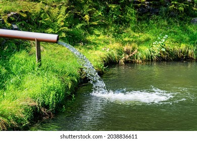 Water flows through a pipe into the lake.