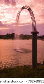 water fountain splashing into a lake a sunset