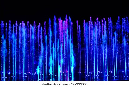 Water fountains on night background. Dancing water fountains. Colorful water fountains show