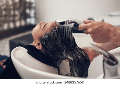 Water, girl child and hairdresser with hair care in salon for shampoo, treatment or conditioner. Washing, beauty and client with hands of stylist for cleaning, luxury massage or service by basin - Powered by Shutterstock