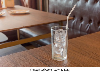 The water in a glass on the table, wood, light windows.