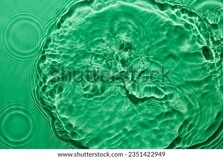 Water green surface abstract background. Waves and ripples texture of cosmetic aqua moisturizer with bubbles
