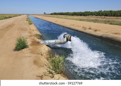 Water gushes from pipe into California irrigation canal