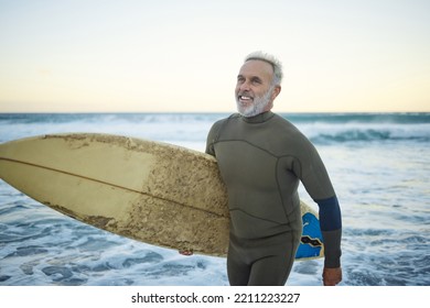 Water, happy and man surfing at the beach on a tropical holiday in Hawaii during sunrise in summer. Mature surfer with smile for the waves in ocean on vacation on an island for travel and adventure - Powered by Shutterstock