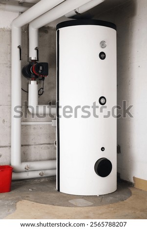 Water heater in boiler room of residential building. Hot water heating system in service room or basement. Smart circulator pump with return and supply pipes. Lucerne, Switzerland. Selective focus.