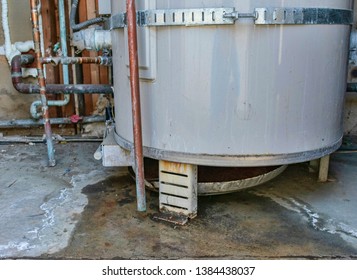 Water Heater Leaks From The Bottom To The Floor. Overflowing Water Heater Drip Pan. It Is Time To Call A Plumber Service For Inspection, Repair Or Replacement