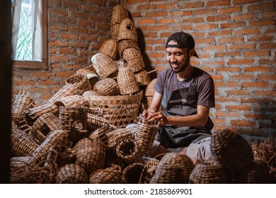 Water hyacinth craftsman man making baskets in village against brick wall background
