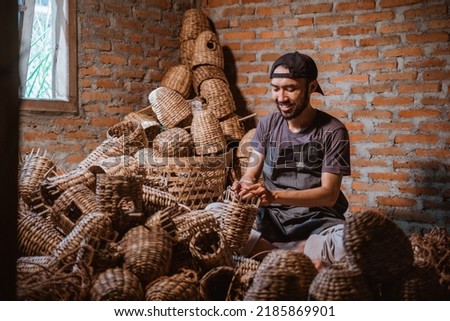 Water hyacinth craftsman man making baskets in village against brick wall background Foto d'archivio © 