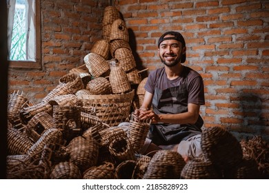 Water hyacinth craftsman smiling while making a basket against a brick wall background - Powered by Shutterstock