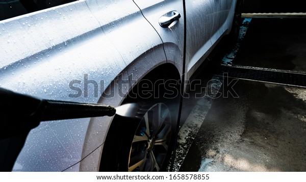 Water jet is depicted\
realistically against the backdrop of white cars being washed by\
jet spray