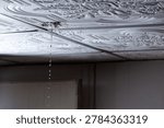 Water leaking through damaged ceiling tile inside house during rainstorm. Ceiling water leak from broken roof or pipe inside residential home