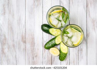 Water With Lemon, Mint And Cucumber On The Wooden Light Background. Water Detox. Top View.