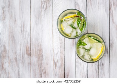 Water With Lemon, Mint And Cucumber On The Wooden Light Background. Water Detox. Top View.