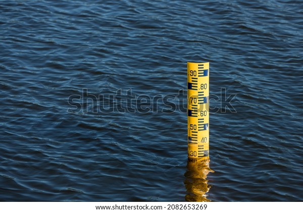Water level meter located in the water of the\
dam. Concepts for natural resources.  Water level gauges in the\
background is the reservoir of water\
