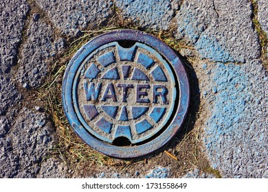 Water Manhole In Blue On A Road.