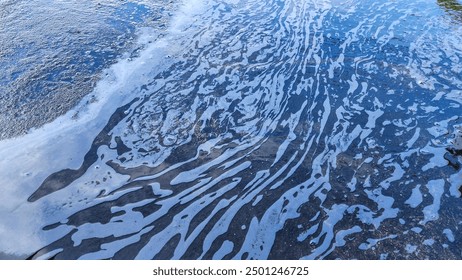 Water mixed with soap bubbles flows along the cement floor. - Powered by Shutterstock