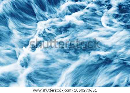Water motion background. Abstract foam smudges texture. Turbulent river flow. Waterfall closeup.