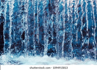 Water in motion, rough current, waterfall, high water. Transparency, crystal, strength. Blue toning, sunlight from above.
